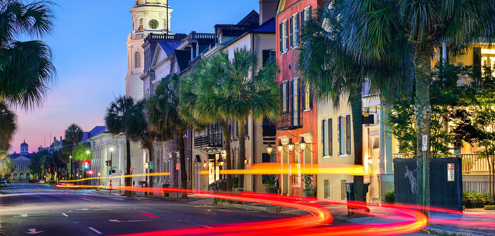 Historic buildings and palmetto trees on Broad Street in Charleston at dusk