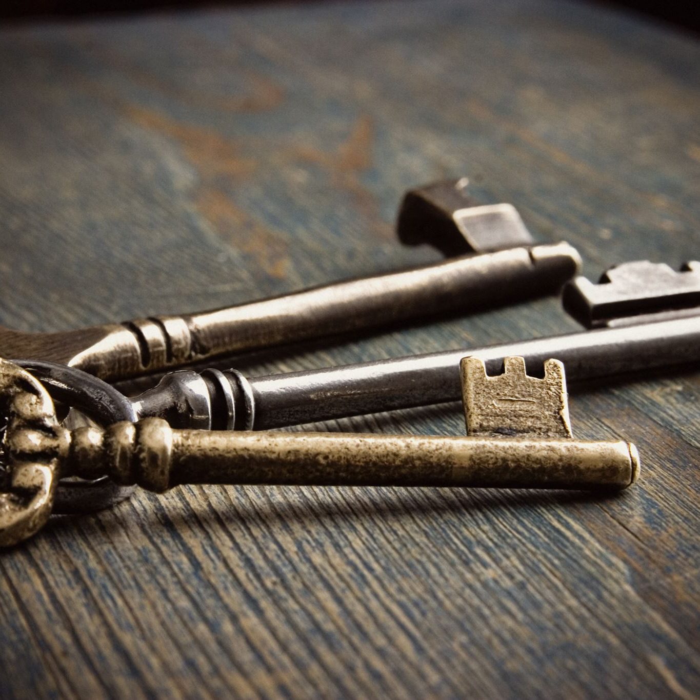 Antique brass hotel room keys on a wooden table